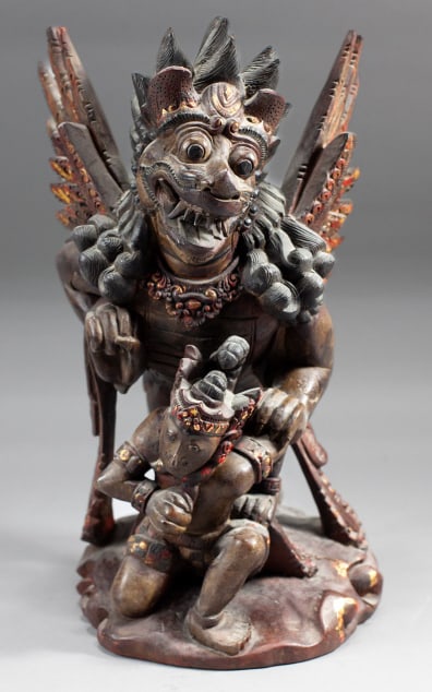 Balinese Singa Bersayap Carved Wood Sculpture: Balinese Singa Bersayap Polychrome Carved Wood Sculpture. Depicts a winged lion guardian with Balinese warrior. Red and gold accent paint. Measures approx 16x14x9". Some cracks to wood from natural sp