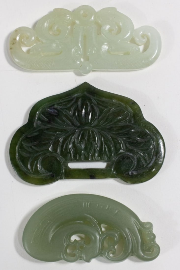 3 Carved Jade Items: All theee carvings are curved lines and open designs, one in white-green, polished (2-3/16" x 1-1/16"); one is celadon green (2"L x 1"W), and one is highy polished spinach green (2-3/8" x 1-1/2") with