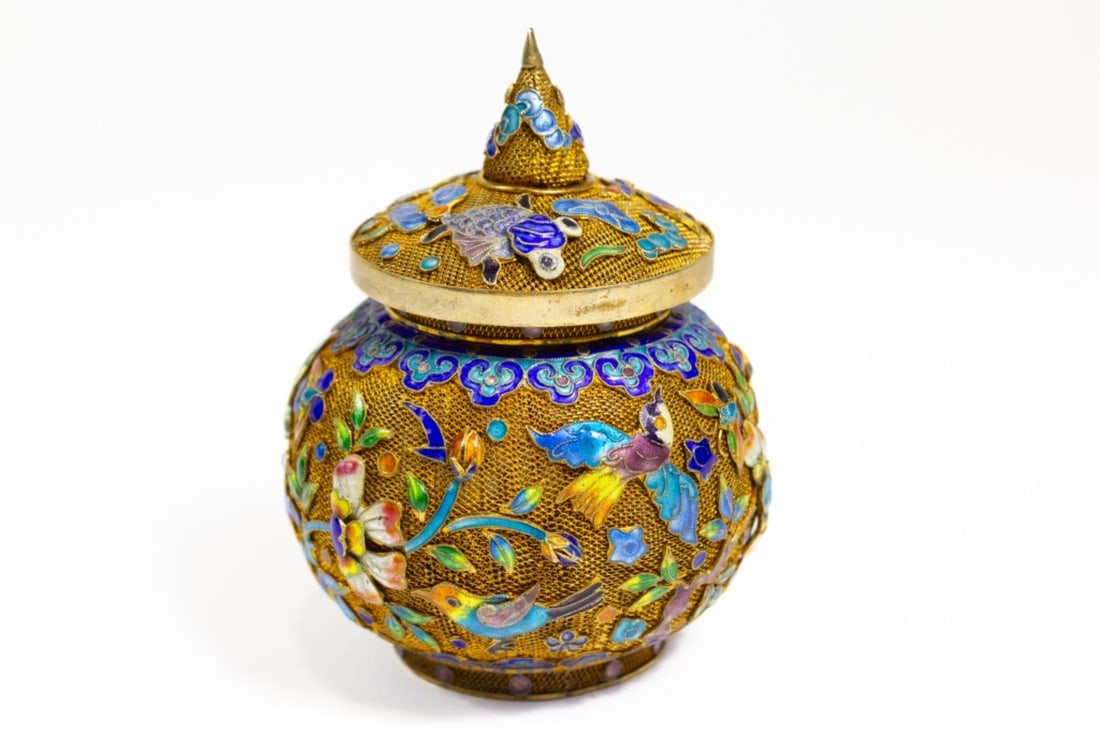 Chinese Enameled Silver Filigree Jar: Chinese gold wash enameled silver filigree jar with lid. Body shows birds in a flowering grove, top shows koi in a pond . Multicolor raised enamels. Small dent to base, overall very good condition. 3"