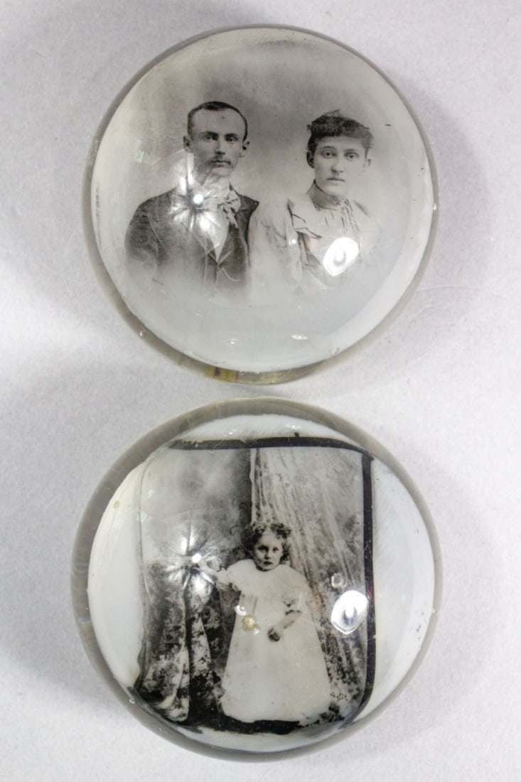 2 Albert Graeser Style Glass Photo Paperweights: 2 Albert Graeser style glass photo paperweights, one photograph of as Victorian couple and the other of a young girl standing in a parlor. Rough pontil marks to base of each . Surface wear particularl