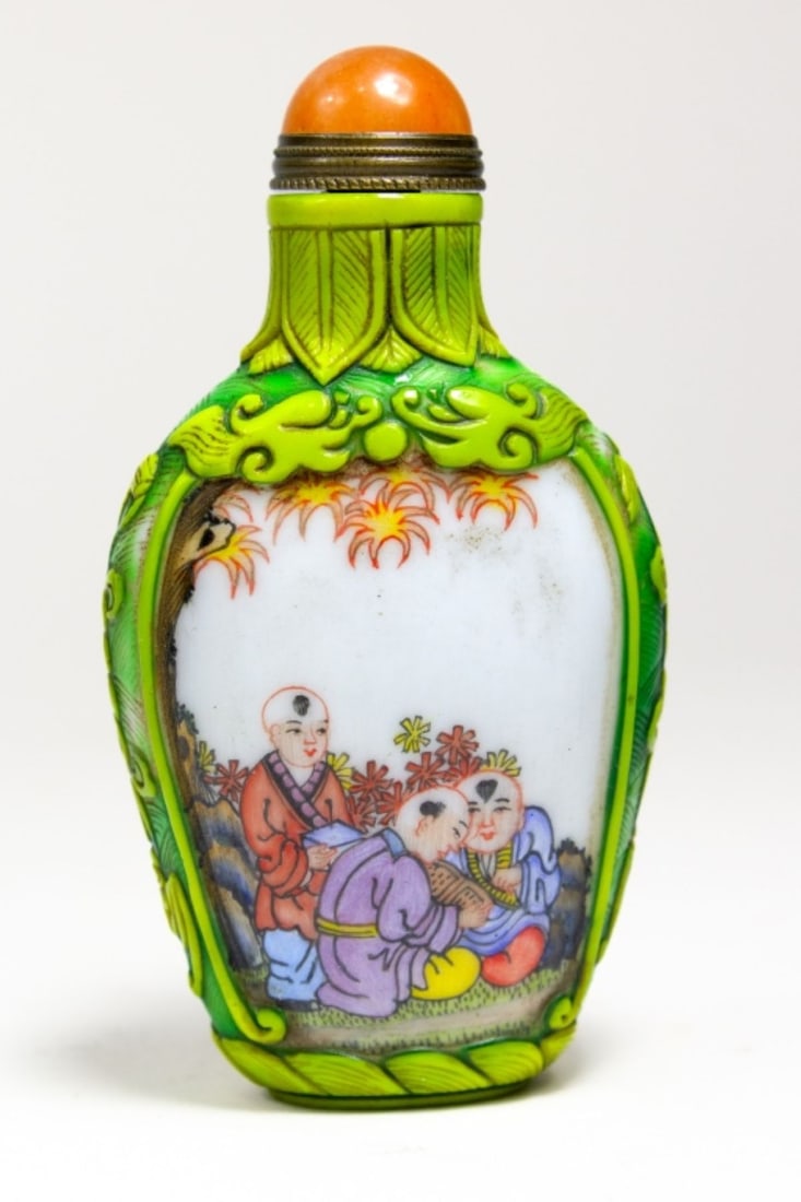 Chinese Enameled Glass Boys Snuff Bottle: Chinese glass snuff bottle. Enameled with scenes of boys playing musical instruments and reading. Applied colored glass frames each scene and at sides. Orange stone stopper with metal spoon intact. Tw