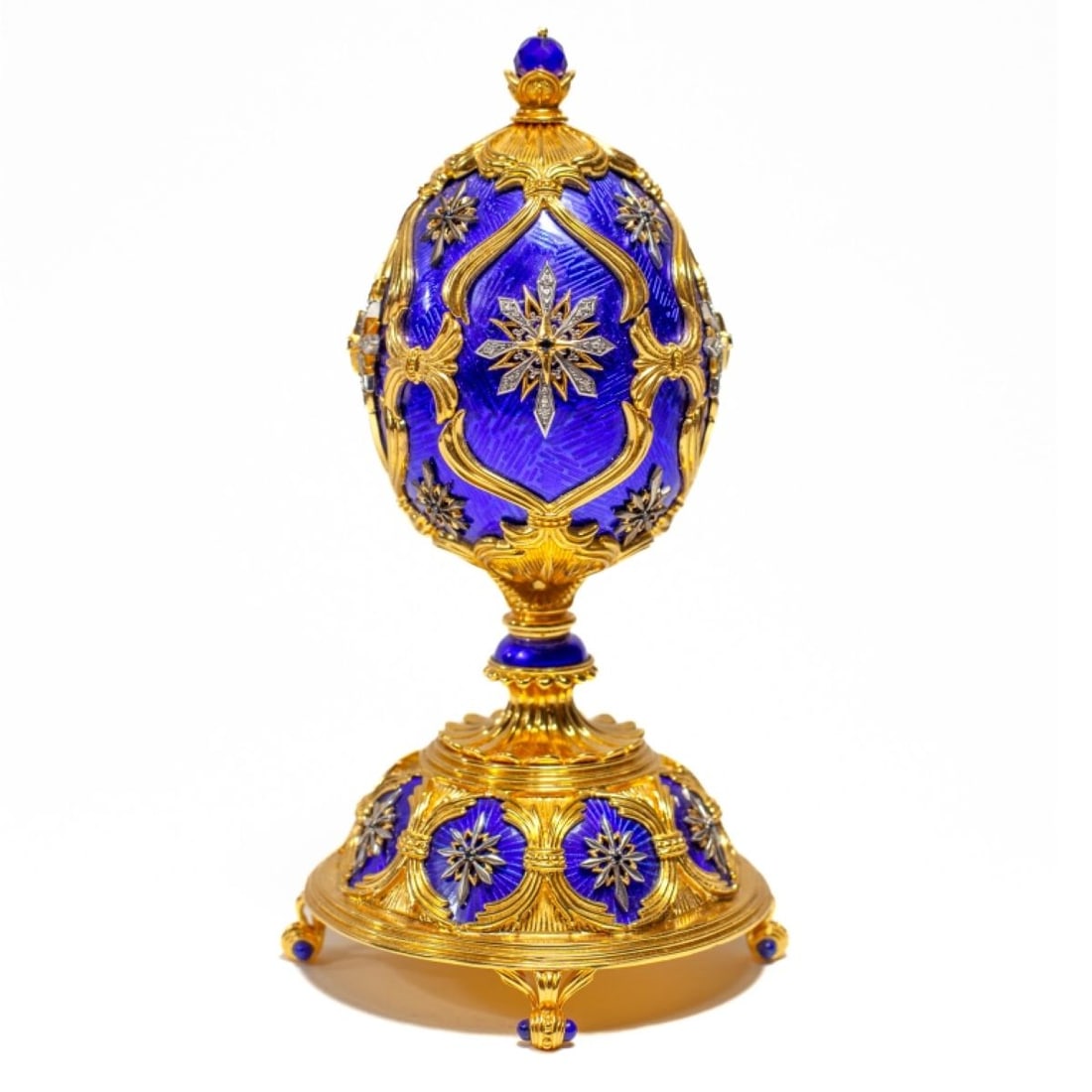 Franklin Mint House of Faberge Stering Silver Egg: Franklin Mint House of Faberge "The Star of the North" Sterling silver & jeweled egg. Gilt silver on blue enamel ground, with dark blue sapphire highlights, leading to a blue stone finial which opens