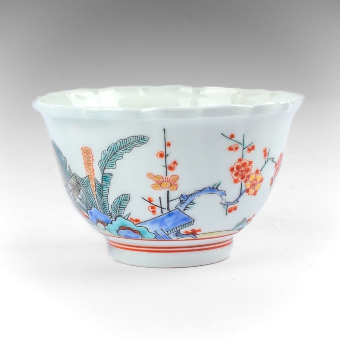 Japanese Kakiemon Porcelain Foliate Bowl: Japanese Kakiemon Porcelain Foliate Bowl. Probably early 20th century. Of ribbed and foliated form in fine white porcelain paste. Handpainted prunus and banana leaf in overglaze enamels, with gilt hig