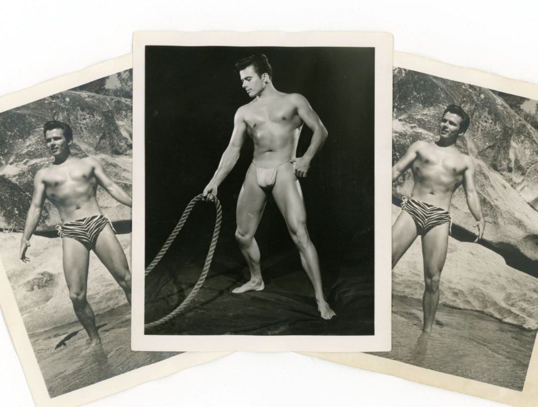 Bob Mizer AMG Nude Male Photos Nude Male Photos: Group of 3 vintage original Bob Mizer AMG photographs; from the estate of the model pictured. (1) Studio shot of model in posing strap holding a large rope. Pencil written XGII-L, 11, and 1-3 to the b