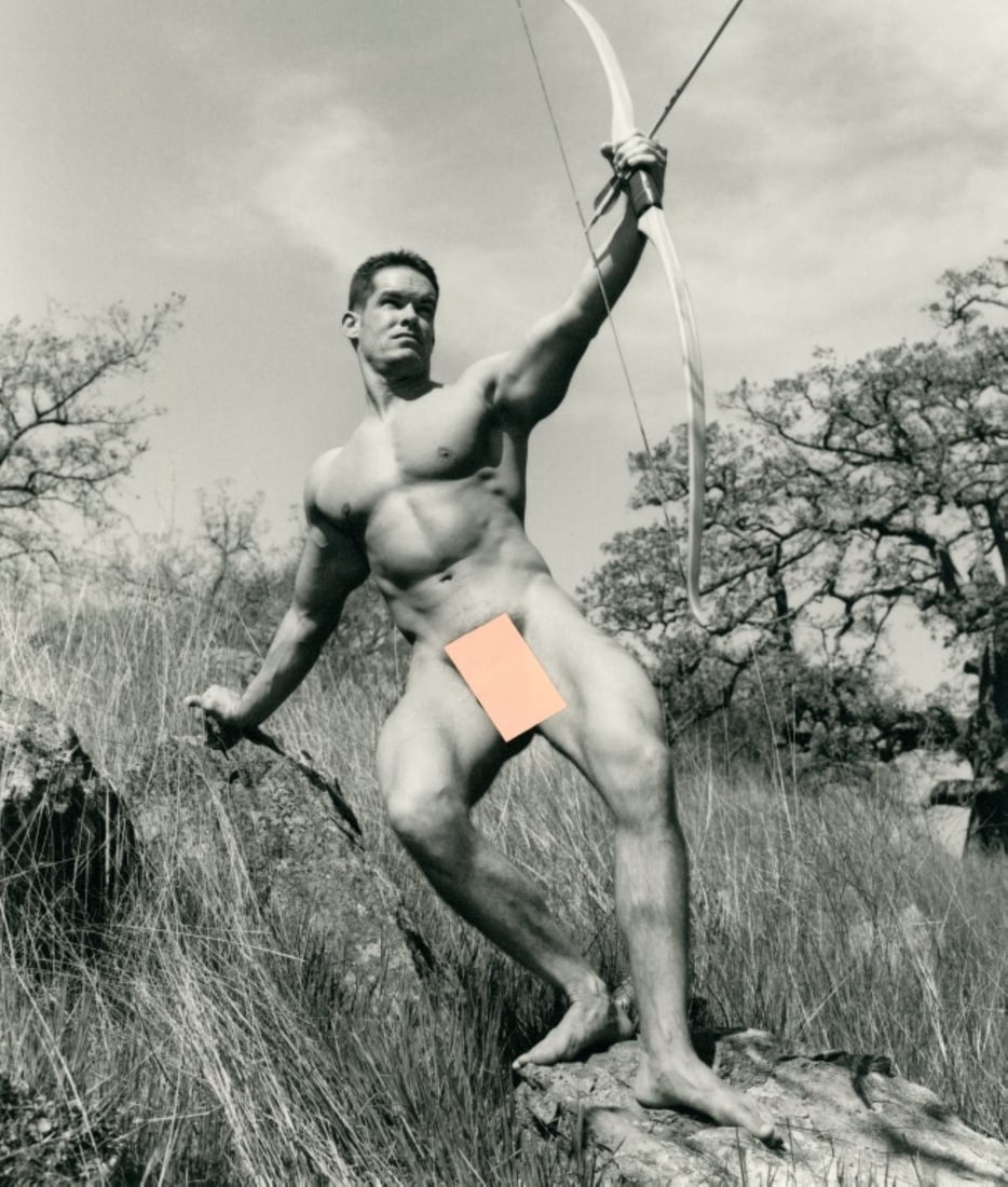 Paul Burkhart (CA) Male Nude Art Photograph: Male nude figure posed outdoors with bow and arrow. Pen signature and Burkhart studio stamp to the reverse. Clear sharp image on slightly textured doubleweight satin paper. Excellent condition. Image 