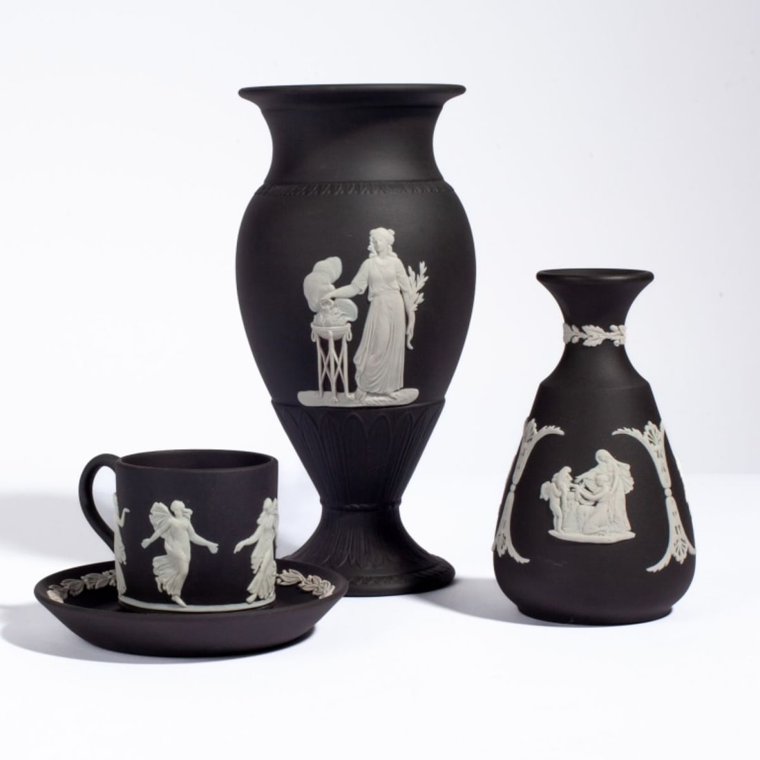 Wedgwood Black White Jasper Vases / Cup & Saucer: Group of 3 Wedgwood black and white jasperware items. (1) Bud vase with classical figures including Pegasus. Impressed WEDGWOOD MADE IN ENGLAND and 77 marks. 4.75" H. (2) Vase with classical figures t