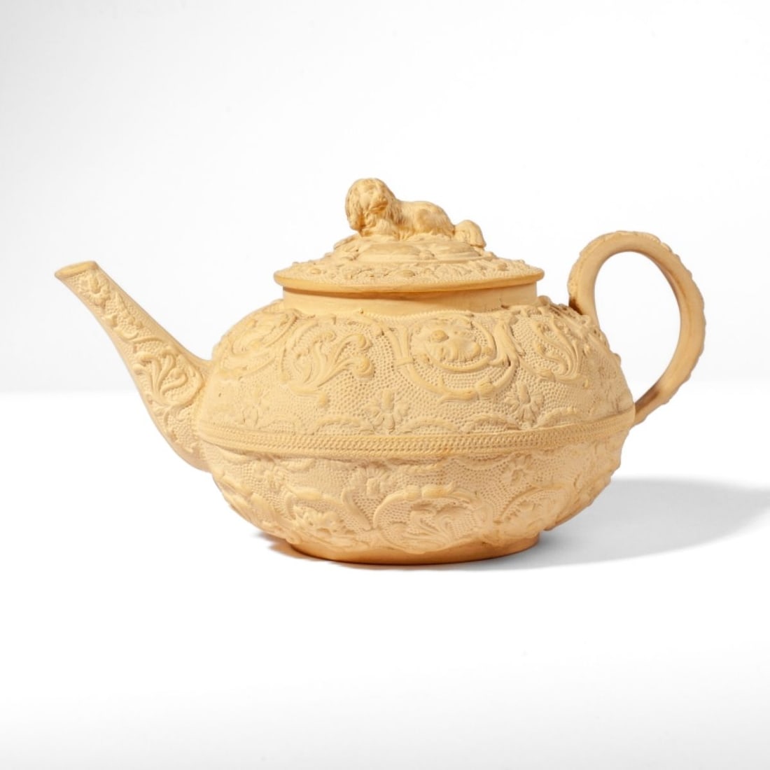 Wedgwood Caneware Teapot / Dog Finial Knob: 19th century Wedgwood caneware teapot with molded Gothic-style scrolling vine design to body. Dog on pillow figural finial knob to lid. Impressed WEDGWOOD mark. Glazed interior. Good condition. 4.25"