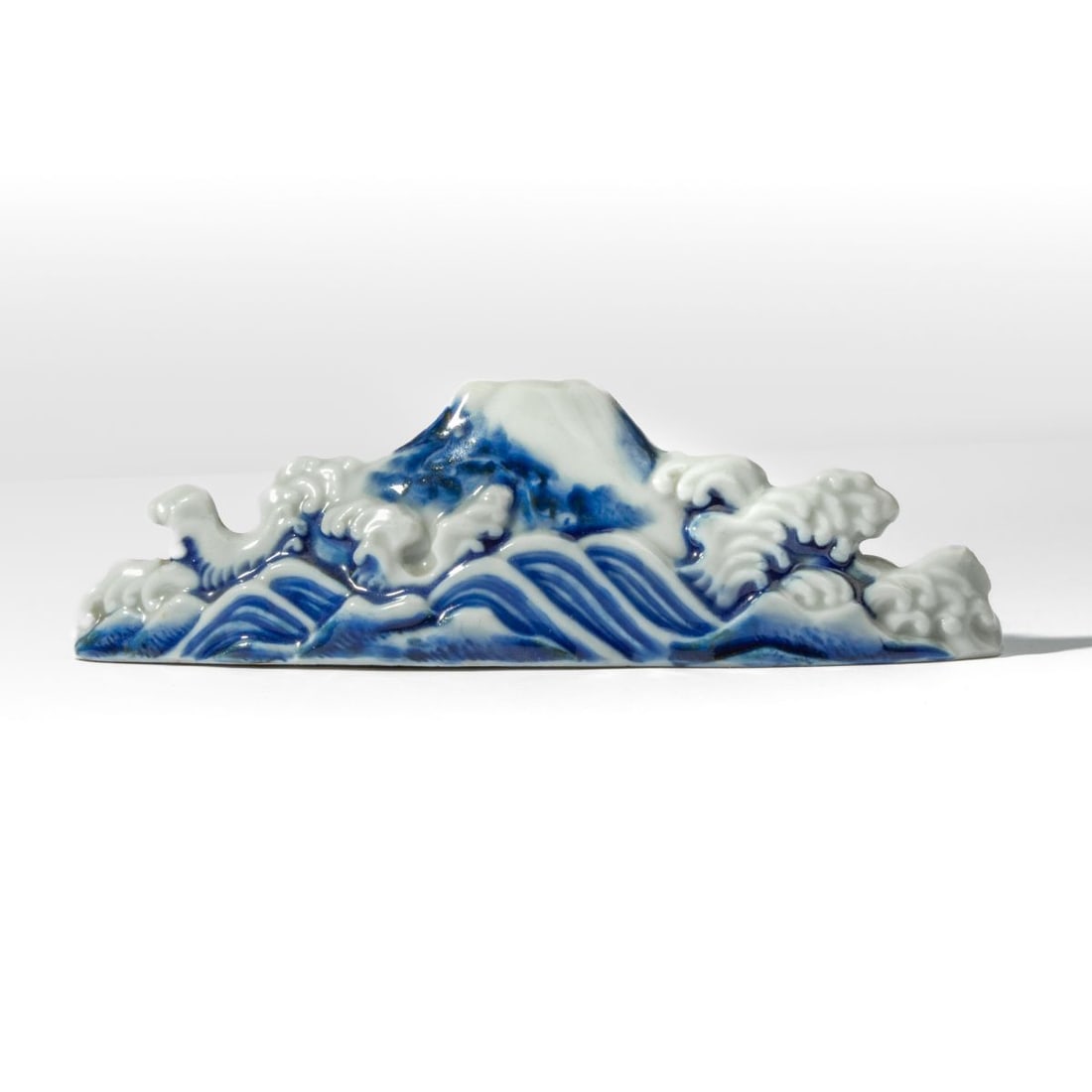 Japanese Hirado Porcelain Mt. Fuji Brush Rest: Japanese Hirado Porcelain Mt. Fuji Brush Rest. Probably Meiji period. Brush rest in the form of Mt. Fuji among waves. Small production crack to base. In good condition overall. 2" H x 6.5" L.