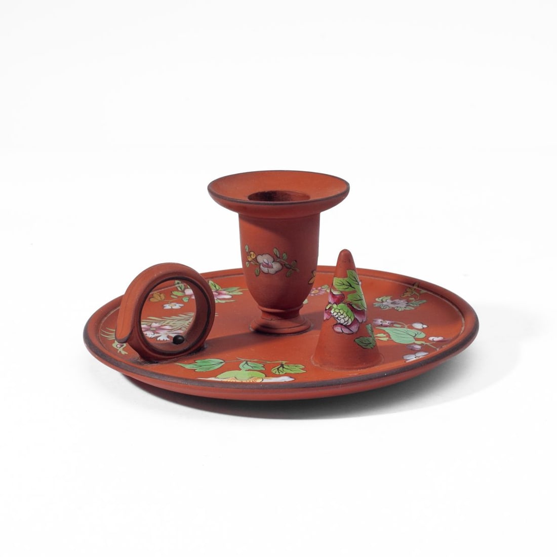 Wedgwood Terracotta Capriware Chamberstick: 19th century Wedgwood Capriware chamberstick. Terracotta jasper ground with handpainted floral sprays in enamels. Impressed “WEDGWOOD” mark to base. Nibble to sconce rim; slight production fla