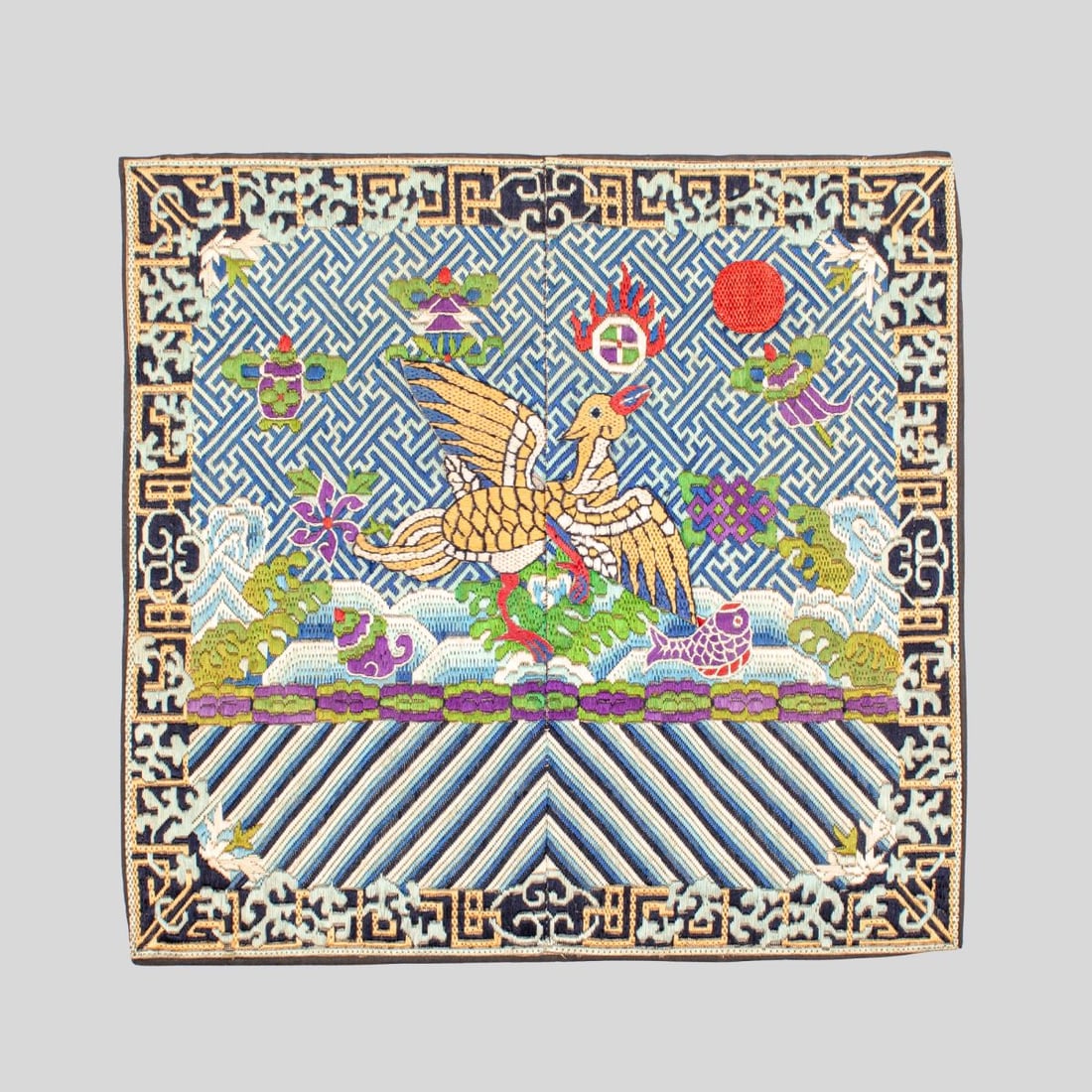 Chinese Embroidered Silk Pheasant Rank Badge: Chinese embroidered silk rank badge. Early 20th century. Depicting golden pheasant in applique above waves and the Eight Auspicious Signs. Chain-stitched keyed border with indigo-dyed silk edge and li
