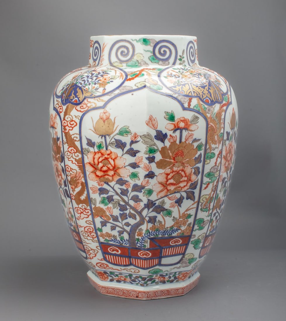 Large Japanese Imari Porcelain Octagonal Vase: Large Japanese Imari porcelain vase of octagonal slab-built form densely covered with panels of flowering peony trees between dragons and phoenixes in underglaze blue, enamels and gilt. Gilt mark to u