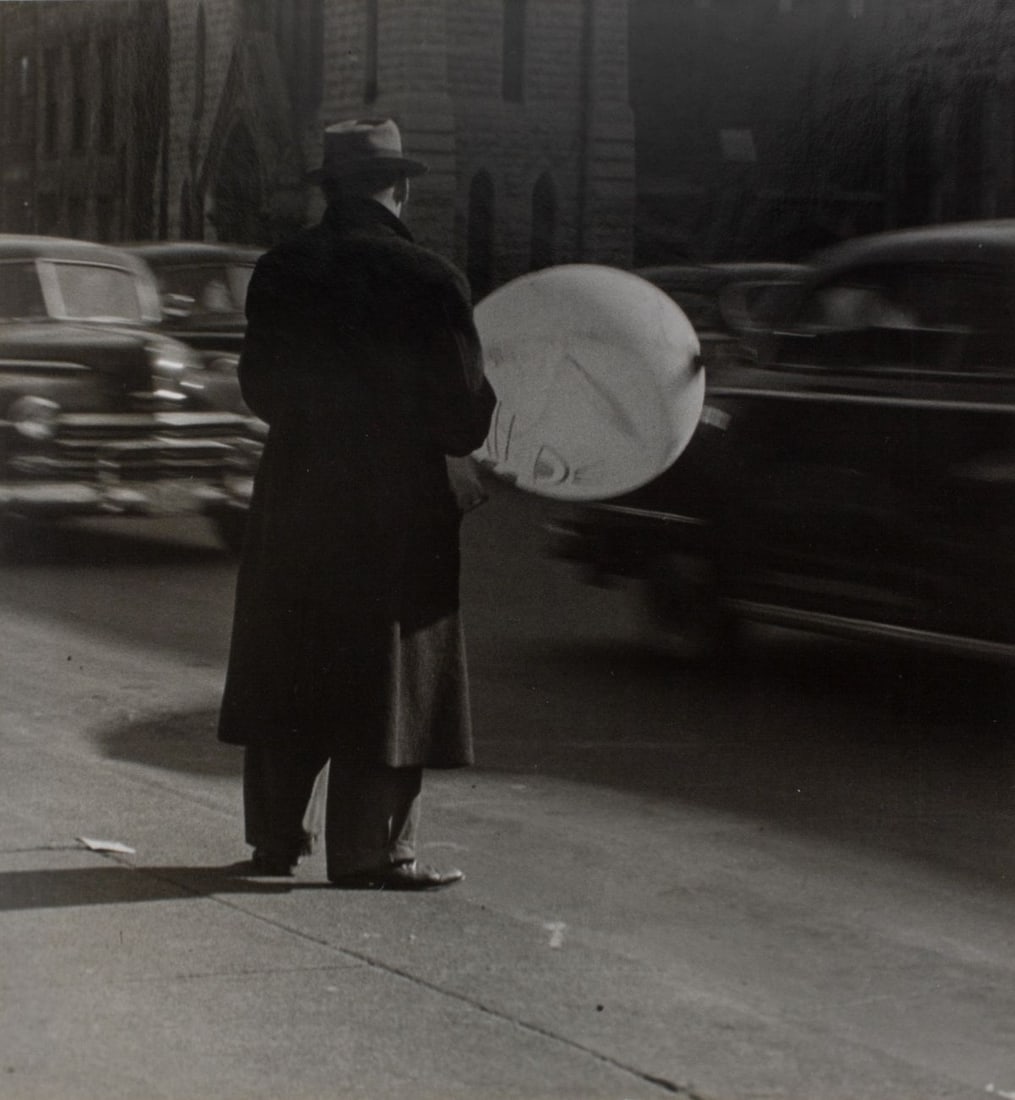 George Gulacsik (WA) Silver Gelatin Photograph: Untitled - Man with Balloon on Sidewalk, circa 1950. George Gulacsik (1923-2010). Silver gelatin photograph printed on satin paper; mounted to textured mat board with ink signature lower left edge. Cl