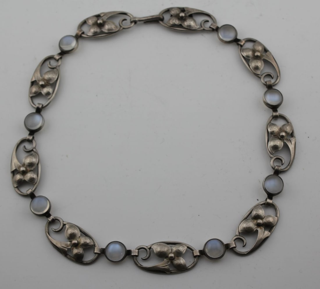 Georg Jensen Sterling and Moonstone Necklace: Georg Jensen Sterling and Moonstone Necklace. Stamped " U.S. A. Georg Jensen Inc. Sterling Hand Wrought 820B". Measures 15" long x 9/16" wide. Includes 8 bezel set moonstones measuring 8mm each. Weigh