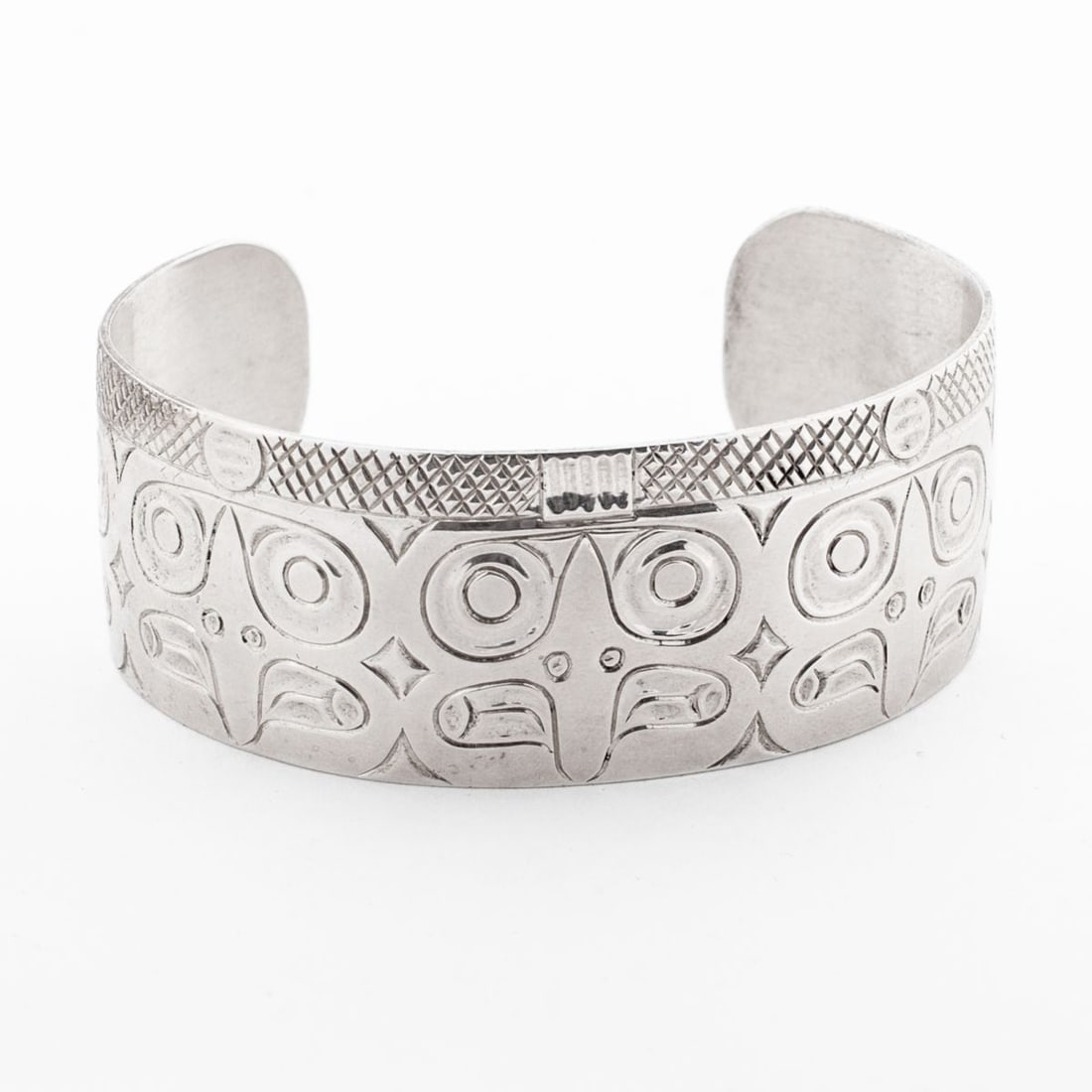 Richard Hunt "5 Eagles" Silver Bracelet 2006: Richard Hunt (b. 1951 Kwakwaka'wakw) "5 Eagles" silver bracelet, 2006. Chased repeated eagle face design. Unmarked silver. Chased signature, title and date to inside band. In very good condition. Open