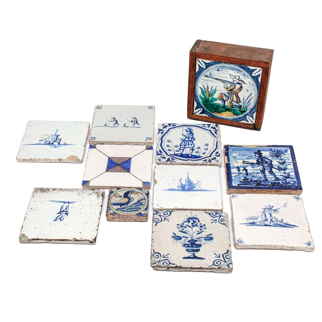 10 Antique Delft Dutch Faience Tiles: Group of ten antique Delftware tiles. Includes depictions of Dutch soldier in landscape, a soldier between flowers, two children playing with wheels, a shepherd, a cupid, a tower, and a church. 17th -