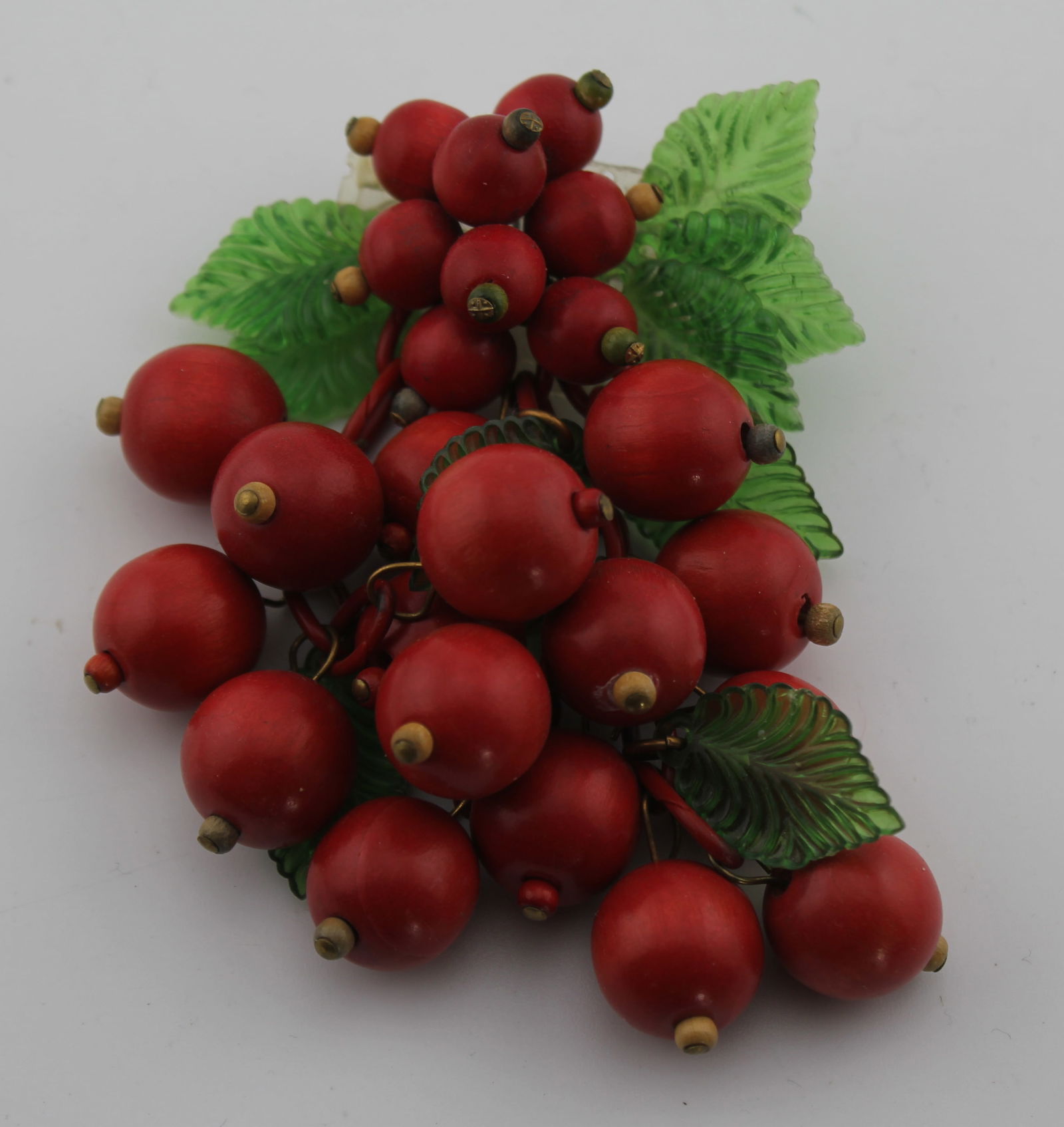 Miriam Haskell Style Dangling Cherry Brooch Pin: Early probably unsigned Miriam Haskell Dangling Cherry brooch pin. 15 dangling wood cherries (with 4 green plastic leaves) on chains below 8 smaller wood cherries. 1 leaf missing to pin back; otherwis