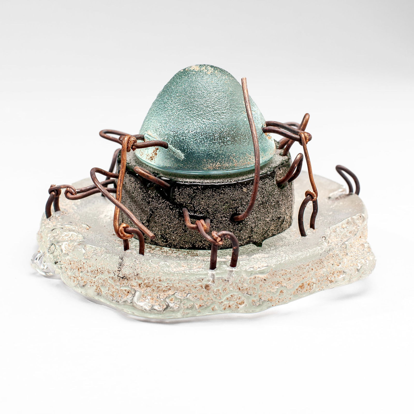 Hank Murta Adams "Round Cake with Ice Cream": Hank Murta Adams (b.1956 New Jersey) "Round Cake with Ice Cream" Mixed Media Glass Sculpture, 1998. Signed and dated on base. Cast glass, copper wire, and sand. Measures 4.5x7". Collection of Marge Le