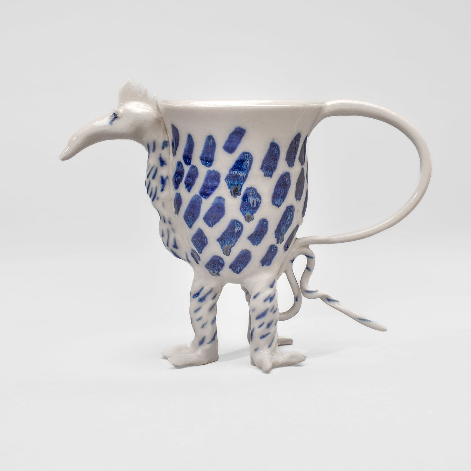 Coille Hooven "Chicken Little Cup" Porcelain: Coille Hooven (1939-2024 California) "Chicken Little Cup" Porcelain Sculpture, 1975. Signed on underside of foot. Functional Mug with 3 feet, tail, and head; cobalt underglaze decoration. Measures 5x7