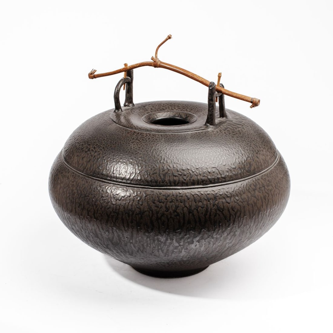 Tom Coleman Large Ash Glazed Vessel: Tom Coleman (b. 1945) large wheel-thrown vessel covered all-over in black beaded ash glaze. Inspired by Japanese ikebana vessels. Circa early 1970's. Incised signature at base. Bent bamboo shoot handl
