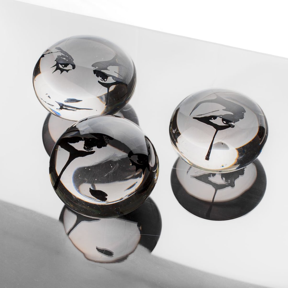 Armelle Bouchet O'Neill "Eyes" 3pc Art Glass: Armelle Bouchet O'Neill (France / Seattle) "Eyes" glass weights with engraved eyes at interior. Unsigned. Two weights with ring display stand; one ring missing. Largest 6" D. Donated by the artist for