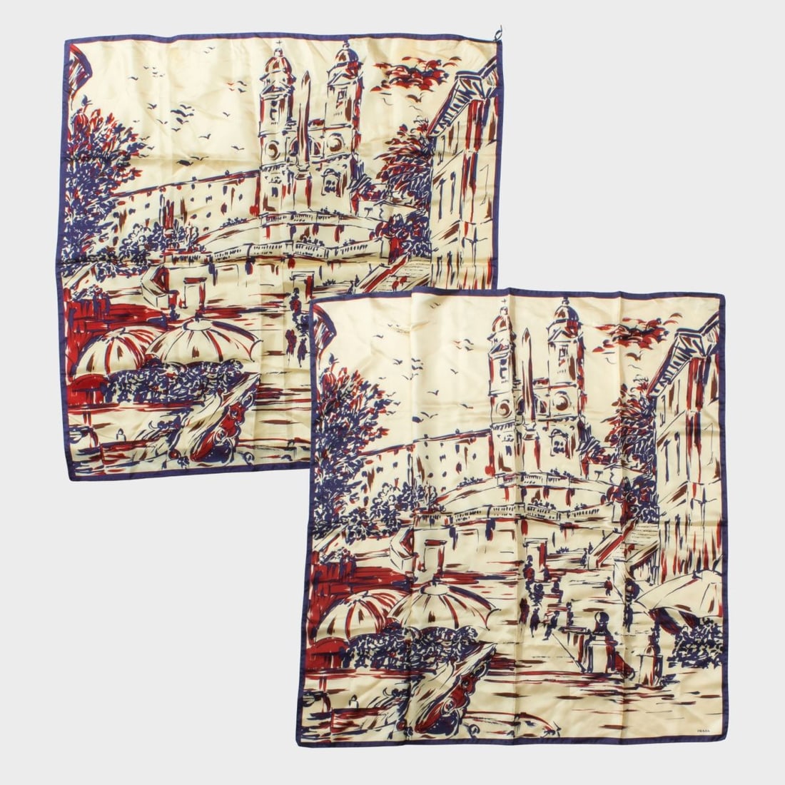 Pair Prada Silk Scarves: Two Prada silk scarves with Rome / Spanish Steps design in red and blue on cream background. Hand rolled and stitched edges. Original labels. One scarf in excellent condition; the other with what appe