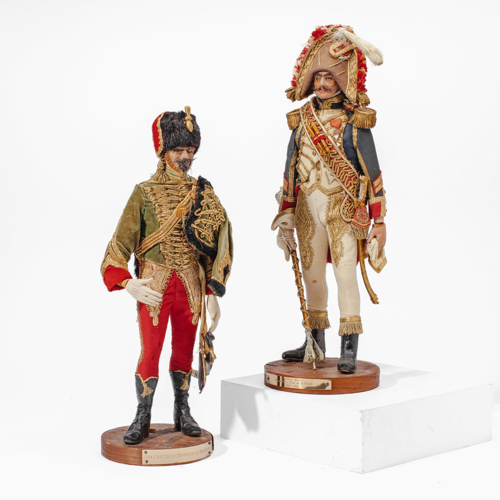 Two Vintage French Military Figurines: Two French military figurines. (1): Captain of the Guides de la Garde Imperiale 1854-1870. Green fabric dolman and pelisse with gilt-wrapped couched thread and red breeches. Left arm has broken off (w
