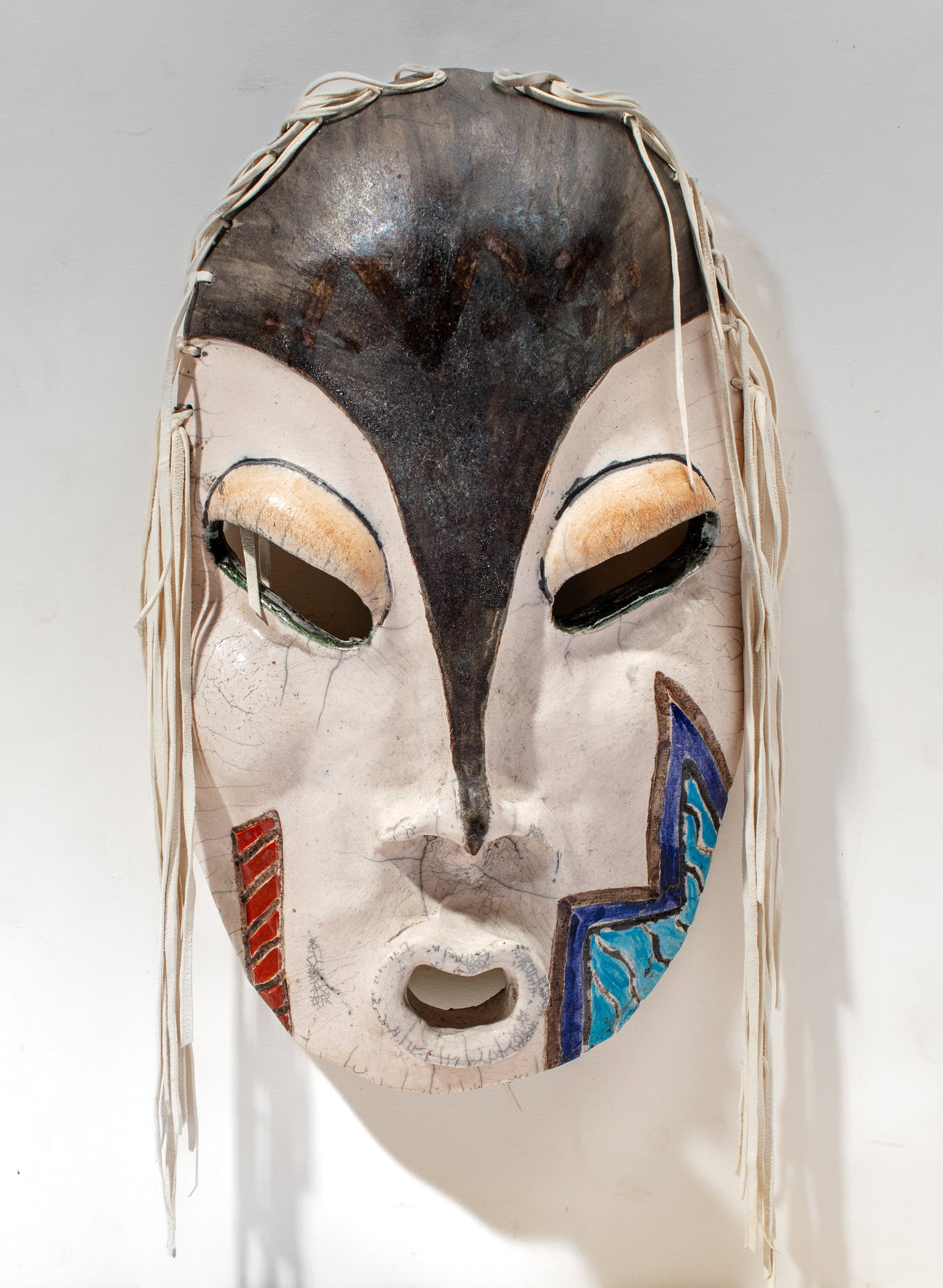 Lillian Pitt "Nehalem Stick Indian" Pottery Mask: Lillian Pitt (b. 1943 Wasco / Yakama) "Nehalem Stick Indian" raku-fired pottery and hide mask. Dated 1986 with incised signature. In very good condition. 14.5" x 9".