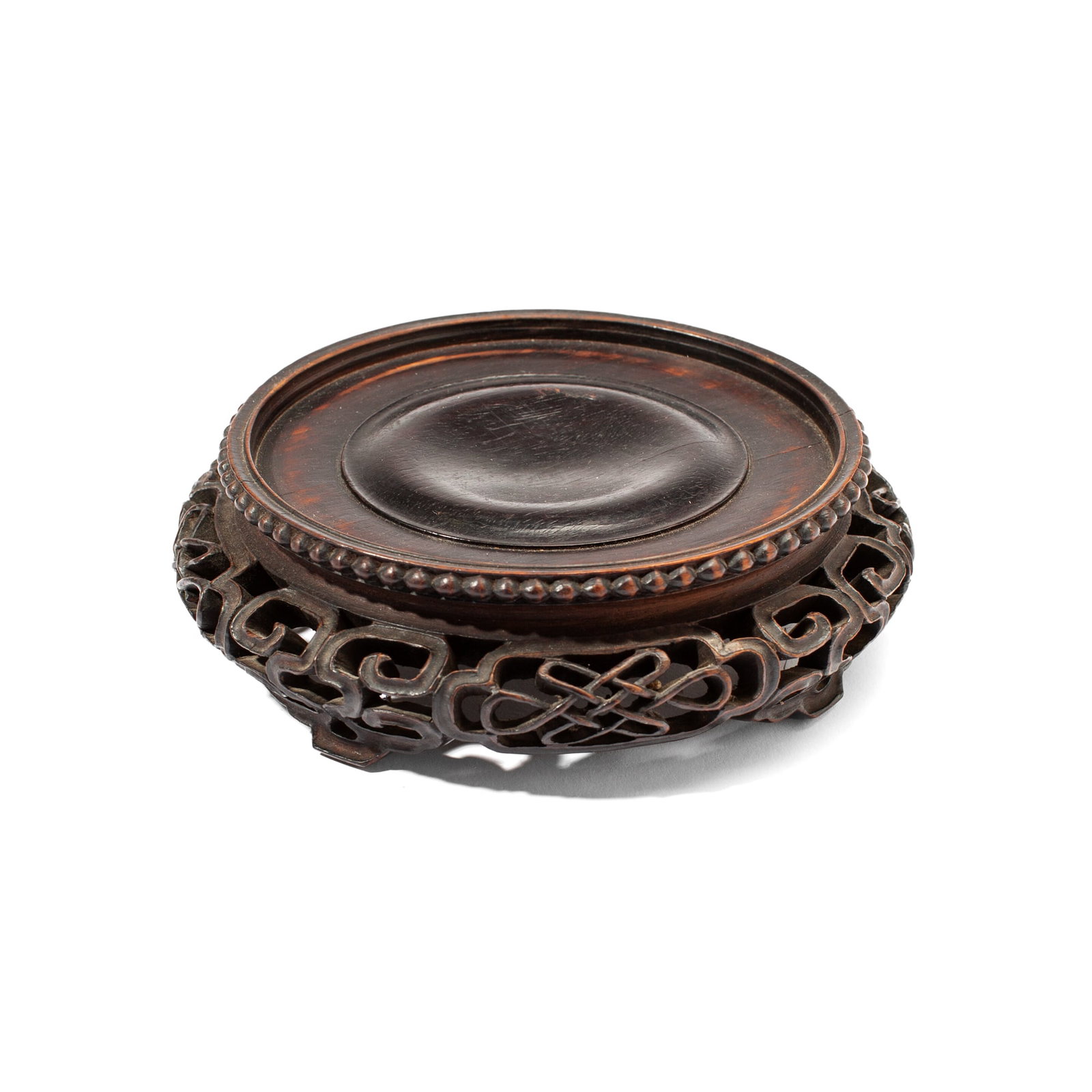 Antique Chinese Rosewood Reticulated Stand: Antique Chinese dark rosewood stand with reticulated openwork carving of thousand-knot emblems between fretworked feet, all below bossed rim. Some loss to two knot emblems and one foot; a few small