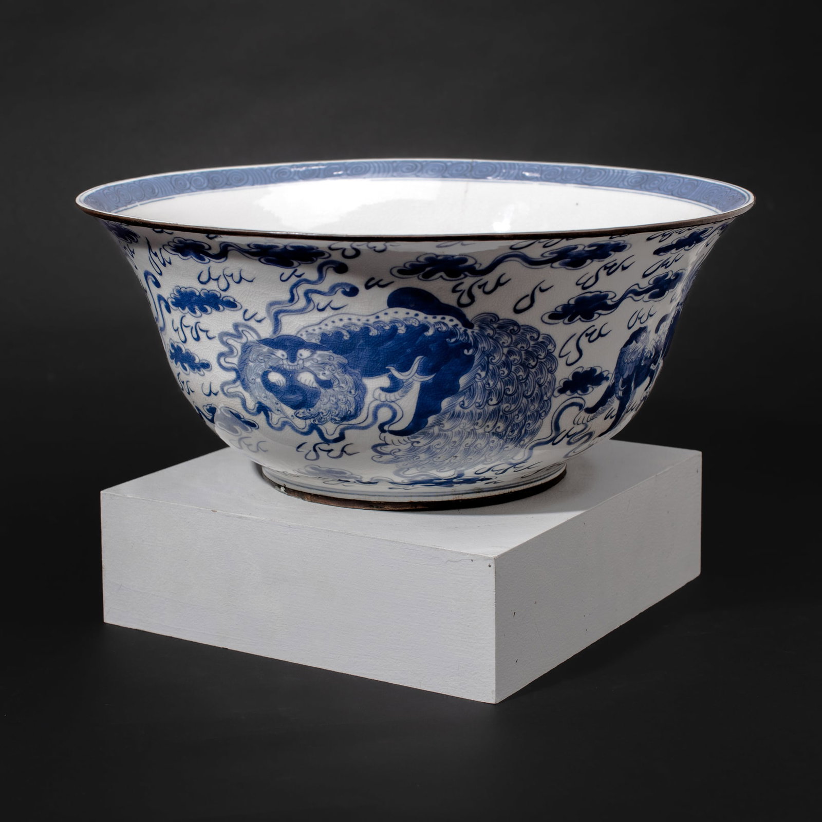 Large Chinese Blue & White Porcelain Foo Lion Bowl: Large Chinese blue & white porcelain bowl with foo lions among clouds. Four-character mark to base. Late Qing to Republic period. Copper bands around foot and rim. Crack extending from rim and some