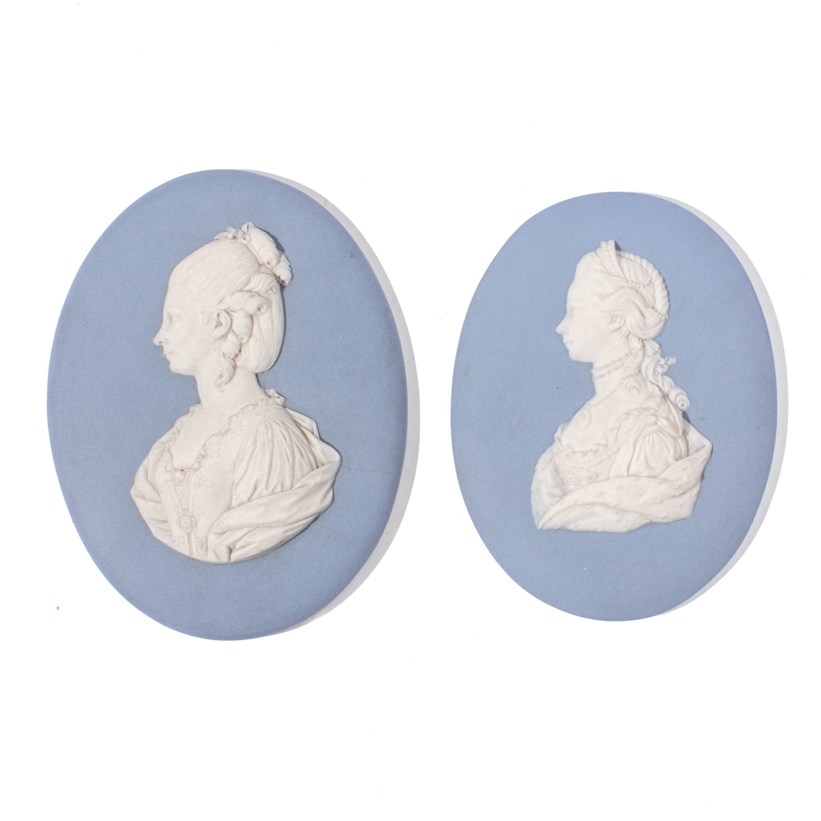 Two Wedgwood Queen Charlotte Portrait Medallions: Two early 19th century Wedgwood portrait medallions depicting Queen Charlotte facing left in white over solid light blue. Each with impressed "WEDGWOOD" marks and accession numbers to reverse. Both in