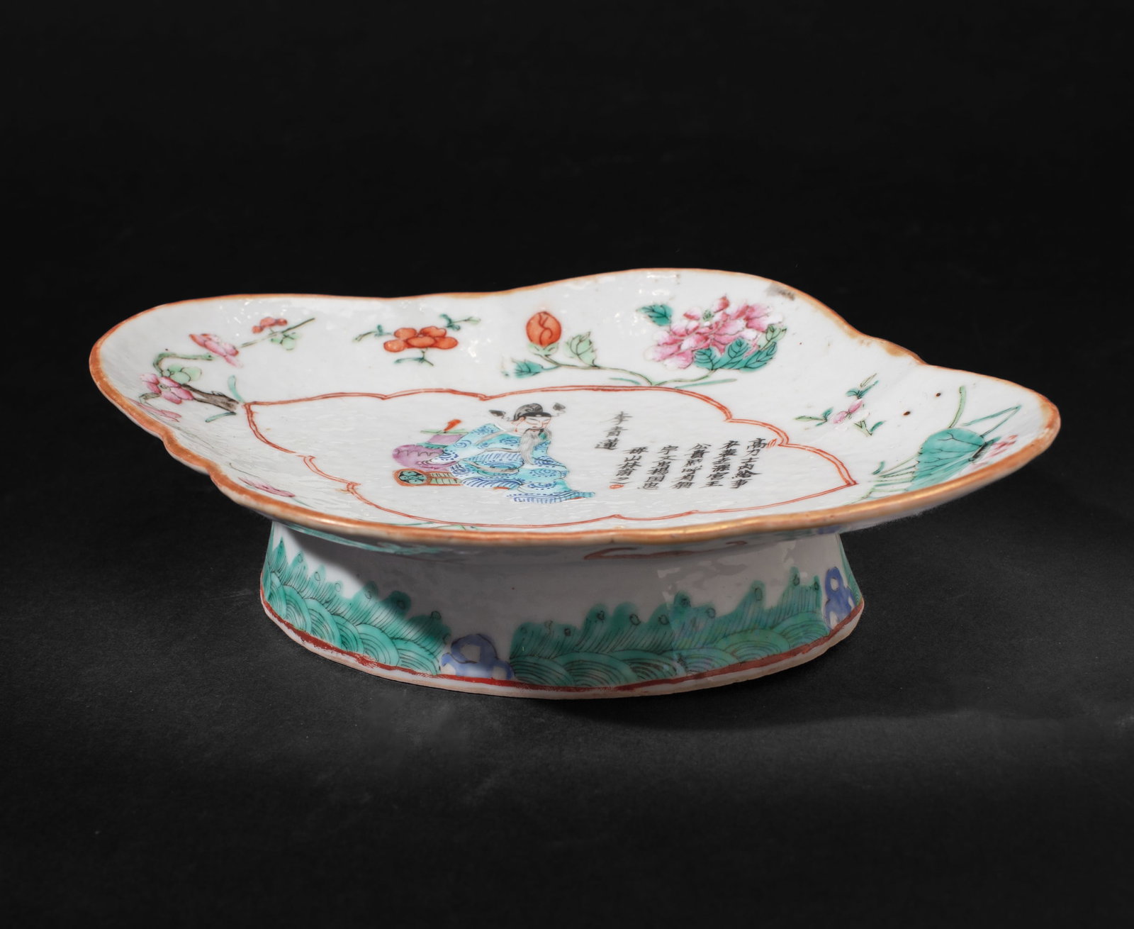 Antique Chinese Famille Rose Enameled Footed Dish: Chinese footed dish with depiction of scholar leaning against antique vase with poetry by Li Bai in regular script; the border having peony, lotus, and prunus blossoms between floral and lingzhi spray