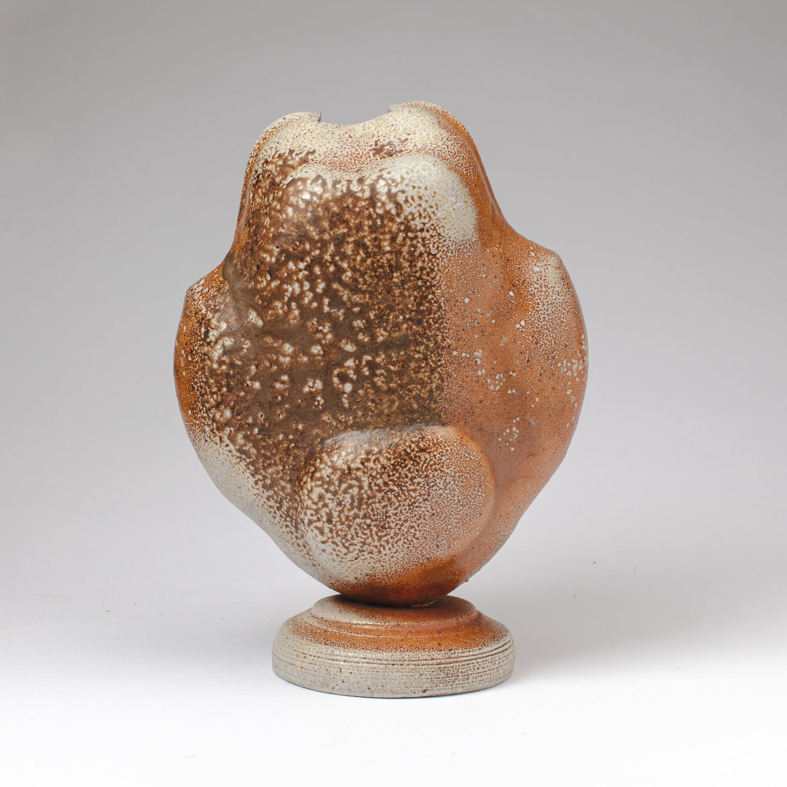 Wally Bivins (WA) Soda Fired Stoneware Footed Vase: Wally Bivins (Washington) Soda Fired Stoneware Footed Vase. Unsigned. Measures 14.5x11x7". Collection of Mike Peck, Seattle WA. Slight lean to top component as made, otherwise excellent condition.