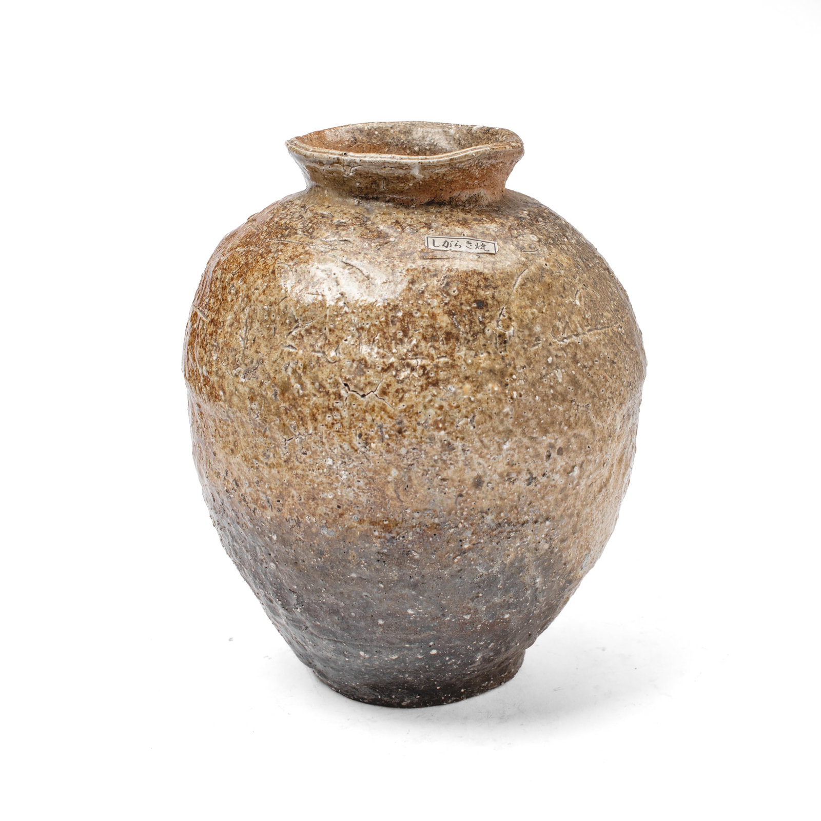 Japanese Shigaraki Ware Storage Jar: Japanese Shigaraki Ware storage jar with thinly-applied section of green ash glaze above burn (koge) mark and pale buff body. Paper label reading "Shigaraki-yaki" at shoulder; numerical mark to unders
