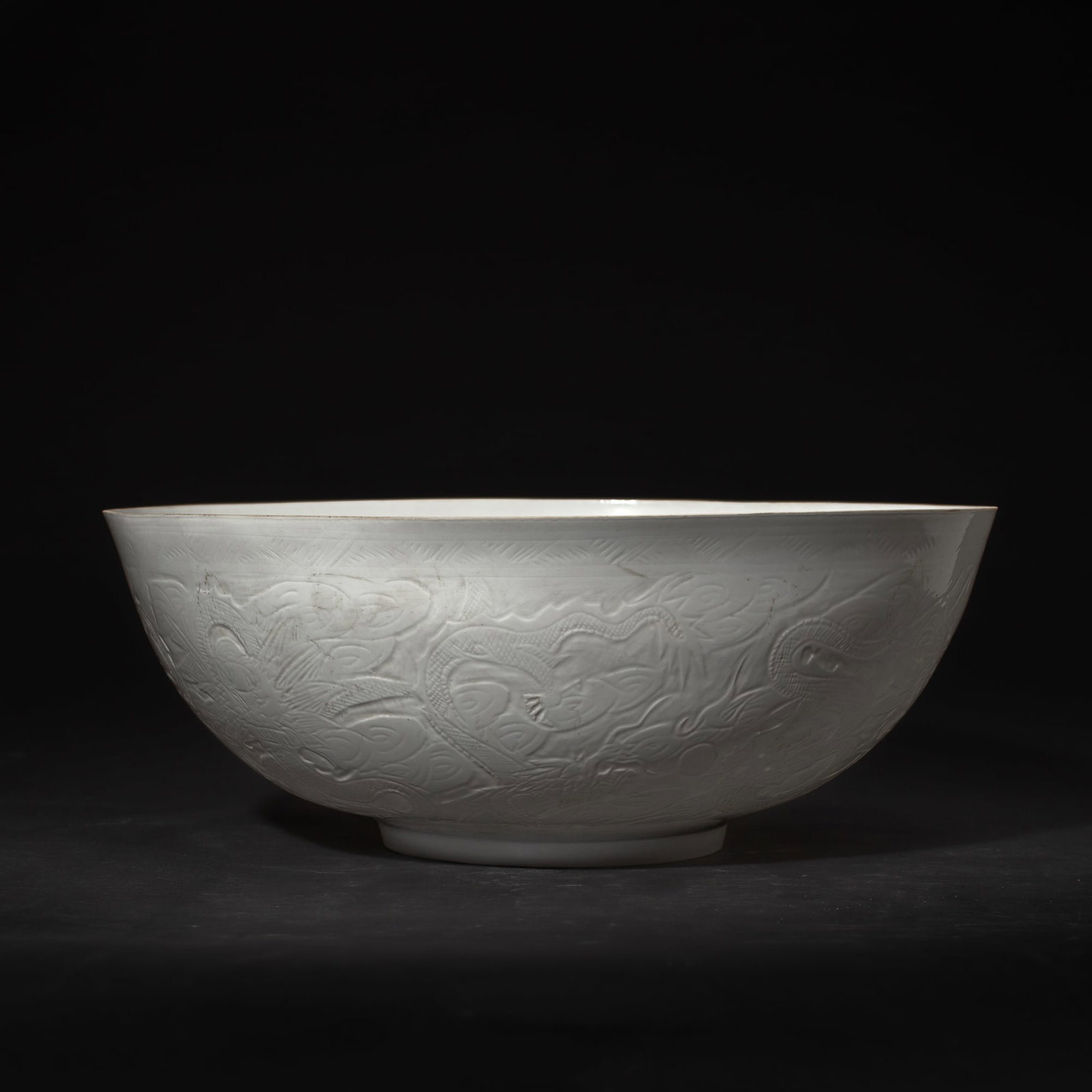 Chinese White Eggshell Porcelain "Dragons" Bowl: Large Chinese white-glazed eggshell porcelain bowl having incised designs of dragons among clouds, their eyes thinly pared down so as to be translucent. Incised four-character mark to underside. In