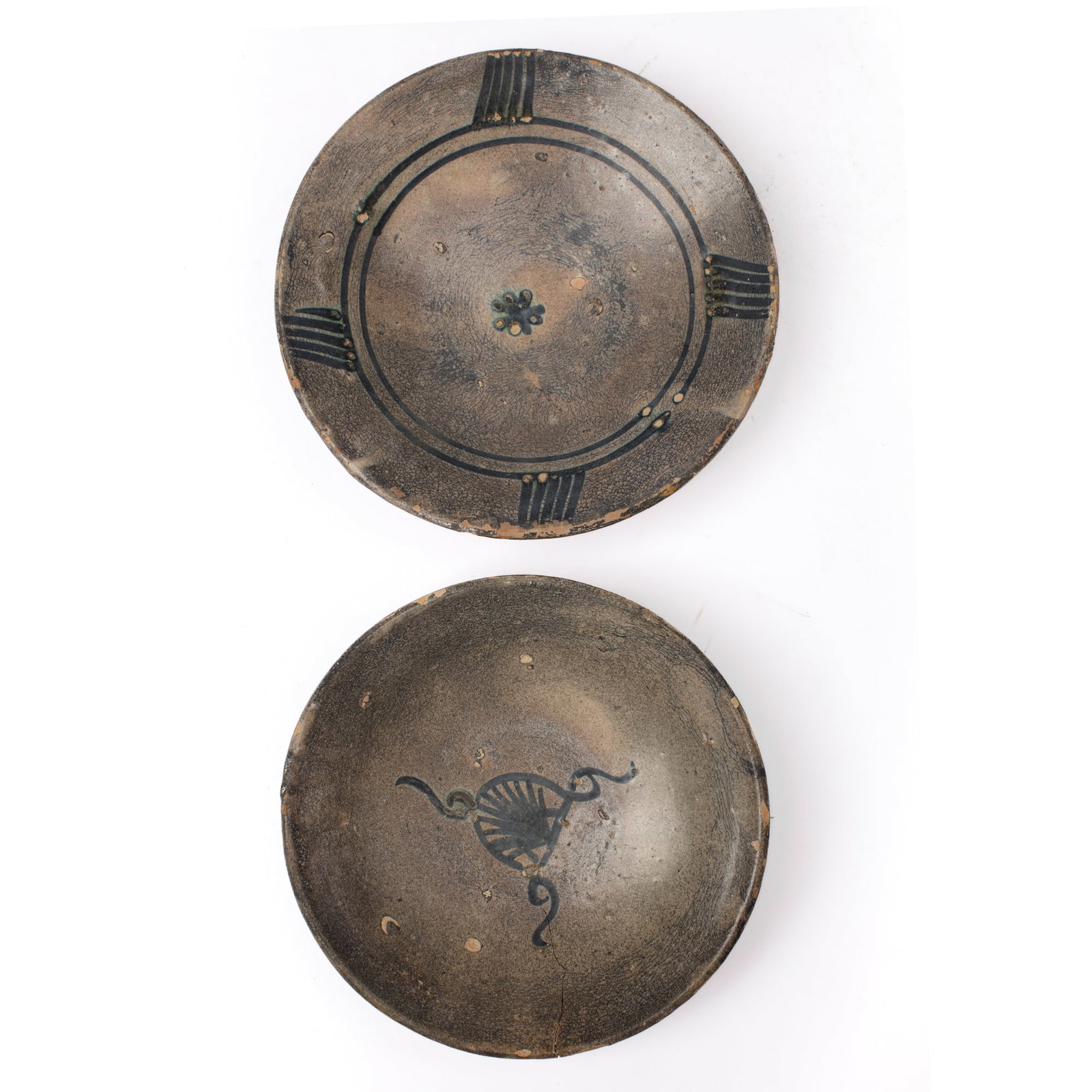 Two Antique Persian Pottery Bowls: Two Antique Persian pottery bowls, probably Nishapur, with floral and abstract motifs in blue-black glaze over glazed ground. Crack to one dish, the other with expected surface wear and in good overal