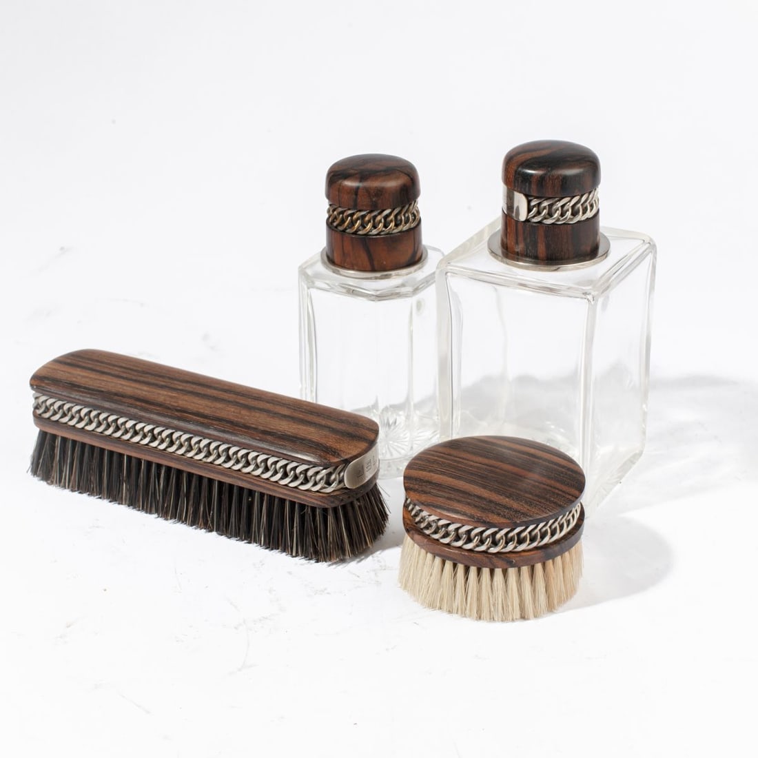 Hermes Paris Ebony Gentleman's Bottles & Brushes: Circa 1930s Hermes Macassar ebony gentlemen's accessories designed by Paul Dupr?-Lafon and made by Ravinet d'Enfert. (1) Larger crystal bottle with silver plate neck, inner stopper, and cut star