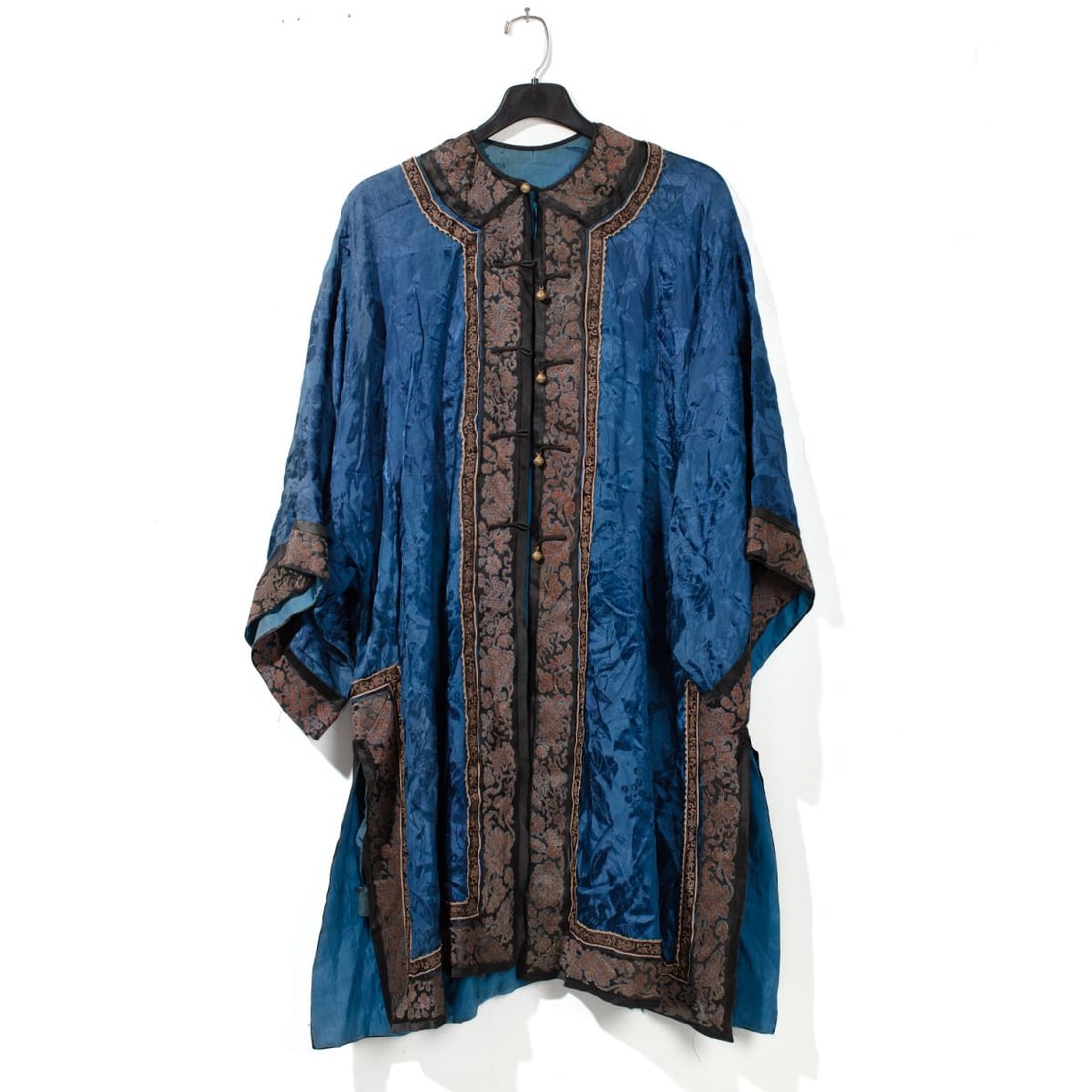 Chinese Export Blue Silk Brocade Robe: Chinese export robe constructed of silk fragments affixed blue silk brocade with hidden floral pattern and turquoise liner, with brass metal buttons. Some wrinkles; silk band bordering hem is loose in