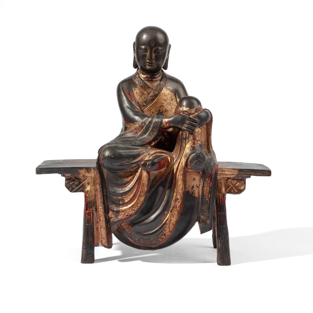 Chinese Ming Parcel Gilt Bronze Scholar/ Immortal: Ming dynasty Chinese parcel gilt bronze figure of a scholar or immortal sitting on a tall bench / table. Areas of applied gilt and red lacquer. Good condition. 11.5" H x 11" W x 4" D approx.