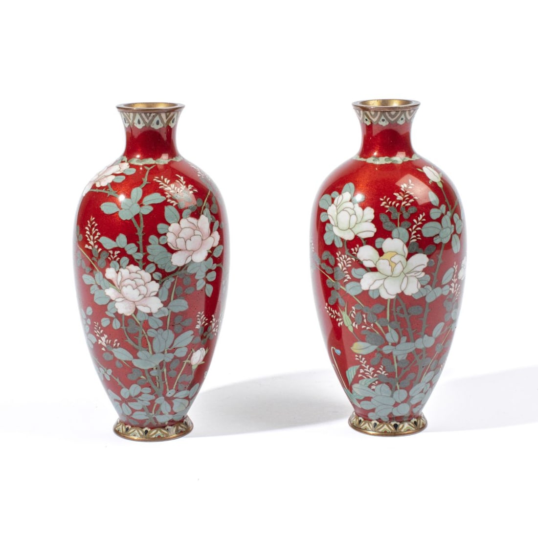 Pair Japanese Silver Wire Cloisonne Vases: Pair early 20th century Japanese silver wire cloisonne vases with white flower and green leafy stem motif on red ground. Excellent condition. 7.25" heights approx.