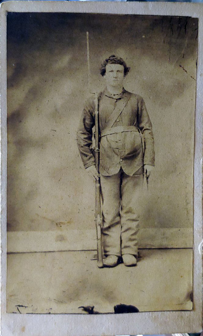 Civil War CDV Photo Soldier with Musket & Gear: A Civil War carte-de-visite photograph showing a Union infantryman with bayoneted musket and accoutrements. The soldier is shown full length in front of a bare backdrop. He wears a four-button fatigue