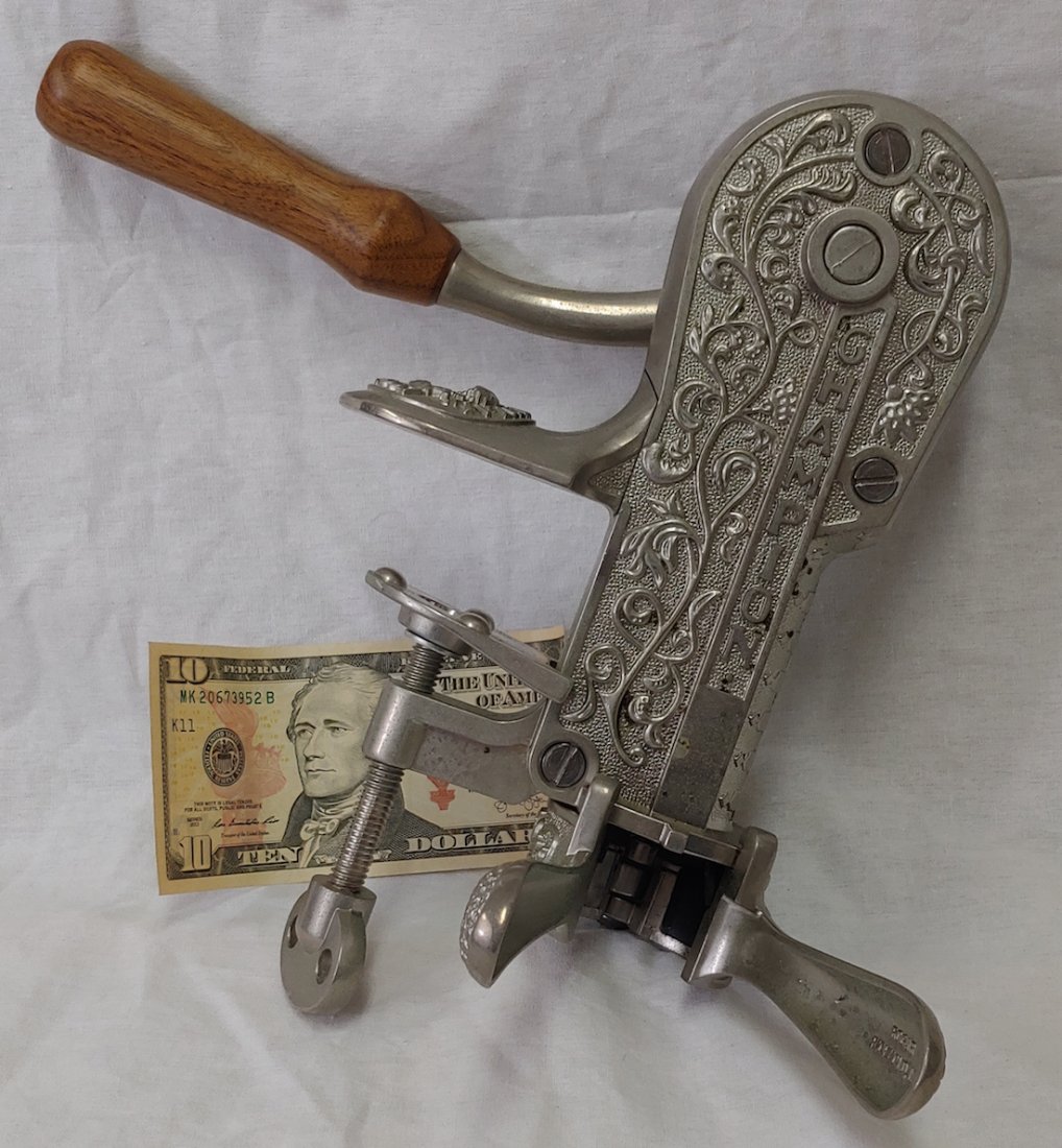 REPLICA OF THE 1897 ROGAR CHAMPION CORKSCREW: A working reproduction of a very classy corkscrew that clamps to a counter, holds the wine bottle by the neck at bottom and draws the cork in one rotation of the lever. Marked "Champion," and dated 18