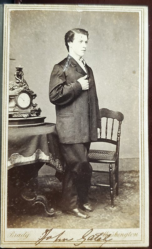 JOHN GATELY IN A BRADY, WASHINGTON D.C. CDV: -NO RESERVE-A full-standing view with a gilt Brady studios in Washington blindstamp at bottom showing a young man in civilian clothes posed with a wonderful Victorian mantel clock on a table behind hi