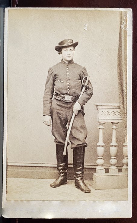 NATTY PENNSYLVANIA CAVALRY OFFICER WITH SABER: -NO RESERVE-This young fellow cradles an officer's sword with a hilt like an infantry foot officer sword, but with a long, curved blade and cavalry style scabbard that fits with his tall boots, short 