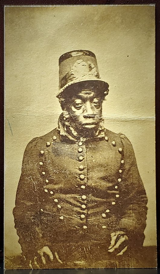 JACK LEE OR BLACK JACK CDV IN UNIFORM: -NO RESERVE-Formerly in the African-Americana collection of Eugene Robinson, News Pundit and panel member MSNBC, this carte-de-visite shows an older black man in a triple-breasted militia coat and sha