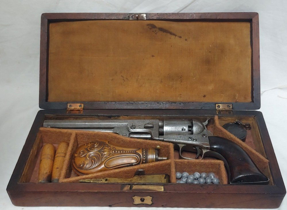 Factory Engraved Cased Colt Navy Revolver: Colt Model 1851 London Navy and original American casing. Overall VG condition. All original and complete and mechanically perfect. Steel is beautifully factory engraved. Grips are deluxe burl wood. T