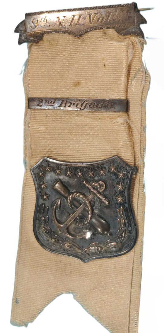 9th New Hampshire 9th Corps Badge: Massive war date silver 9th Corps Badge worn by a soldier in the 9th New Hampshire. This is a three piece silver badge mounted on a four inch long white silk ribbon. Note the clip art illustration sho