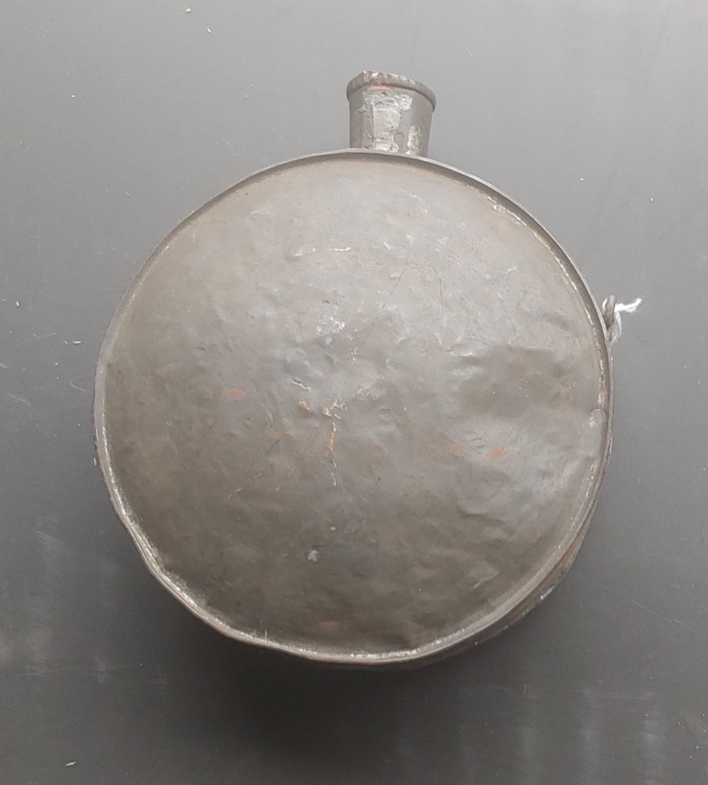 1898 Spanish? Soldier's Canteen.from Cuba: Looks like a Civil War Confederate canteen at first glance. Has two hinged strap brackets. One side of the canteen is brass plated or applied brass. Crude construction. Taped to the edge is an old bro