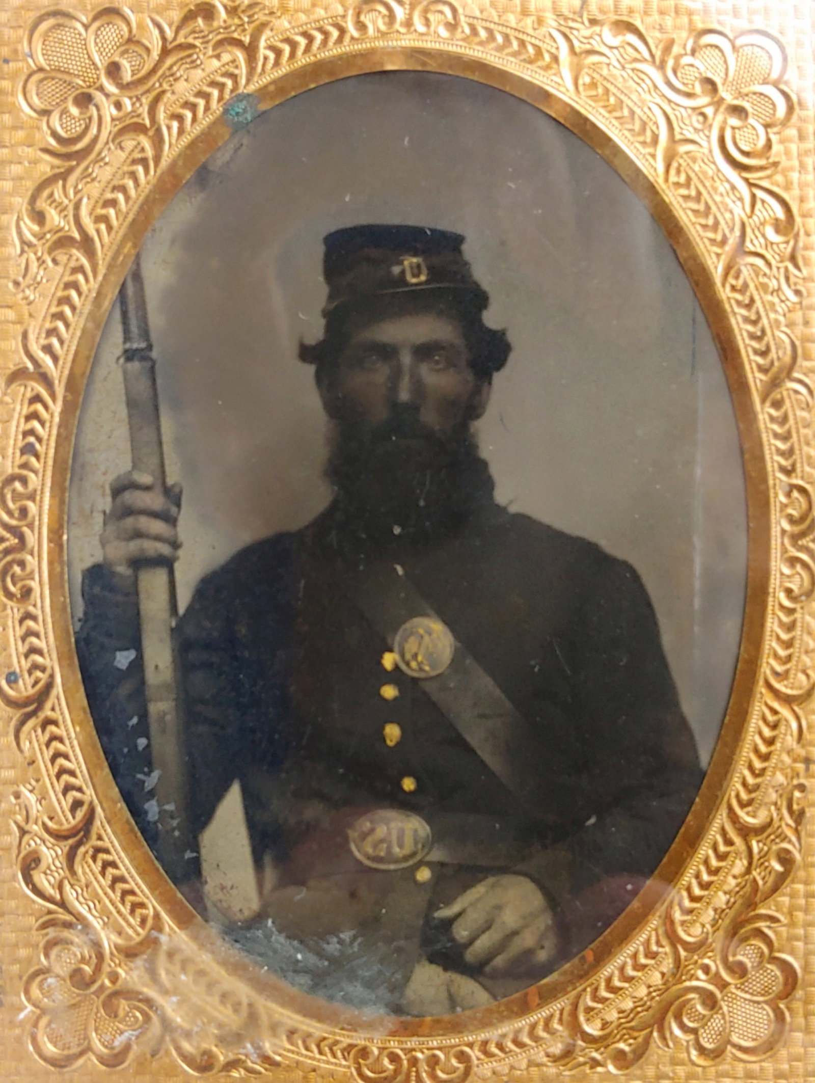 Quarter Plate Tintype armed Civil War Soldier: Very masculine looking subject with a thick beard. He is a uniformed Yankee Infantryman displaying his musket and accoutrements. Good condition in a half case. $35 for packing, UPS shipping, and signa