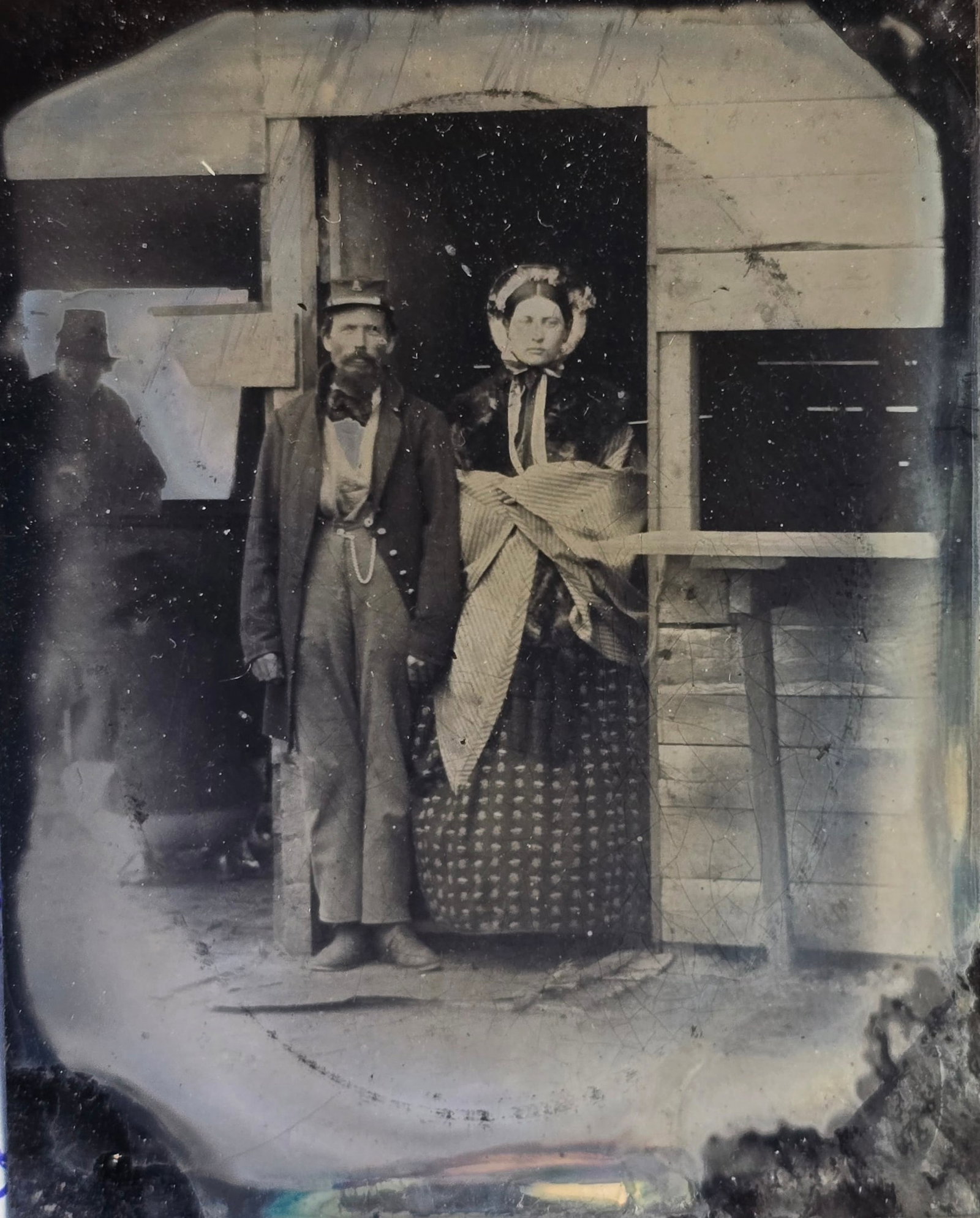 Civil War Soldier with Wife Outdoor Tintype: Fine ninth plate cased tintype showing a Yankee infantryman with his wife standing together near a camp quarters or possibly kitchen. Another soldier is visible in the background - left. The window wi