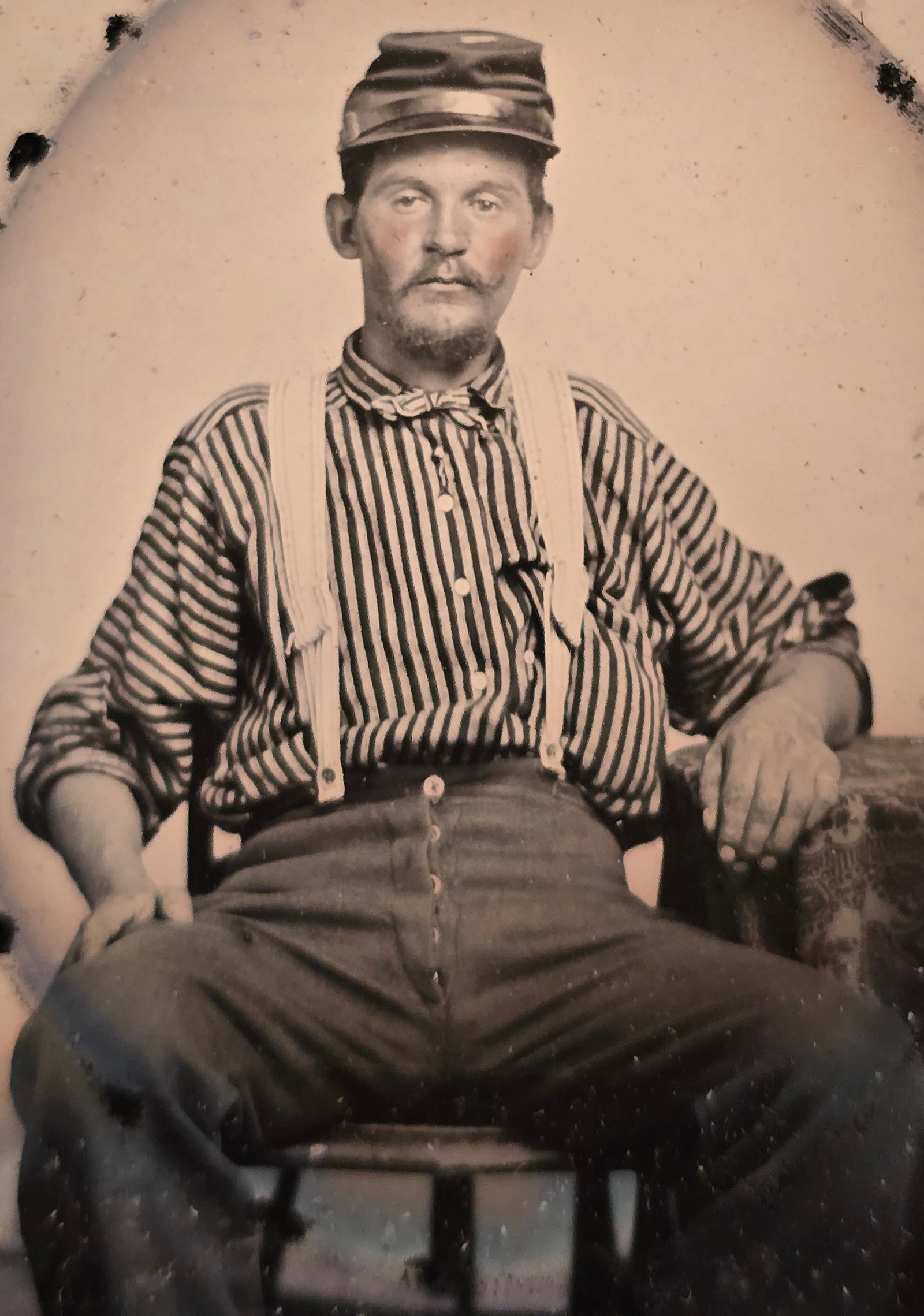 Striped shirt guy: A striking and exceptionally crisp Civil War-era 1/6th plate tintype featuring a character-rich, seated subject sporting a dark military kepi cap, a bold vertically striped work shirt with rolled-up s